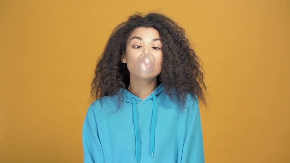 Close up portrait afro american woman  blowing bubble gum