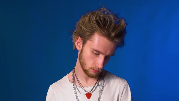 Young Hipster Guy with Beard and Chains Posing for the Camera alt