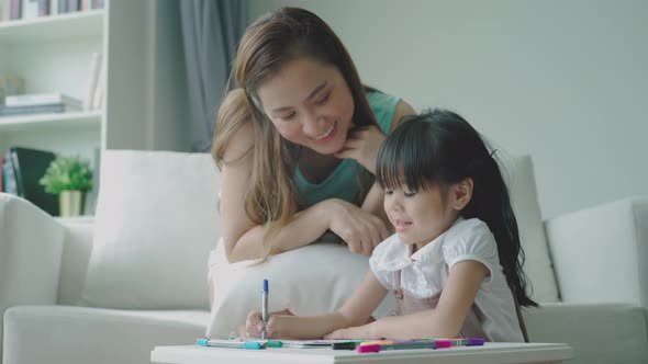 An Asian Mother Teaching Her Daughter at Home 12 alt