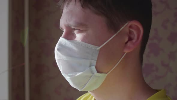 Guy in a Protective Mask Stays at Home on Self-isolation. Prevention and Protection of Health and alt