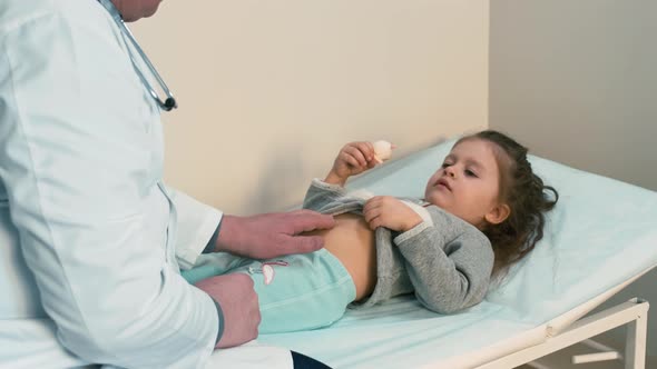 Doctor examining child's stomach