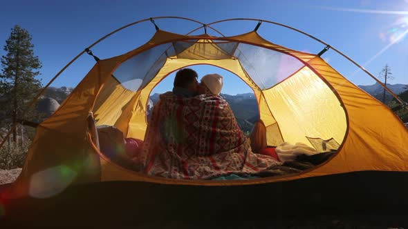 Сouple in Love Sit in an Open Tent, Wrapped in a Blanket and Admiring the Nature of Yosemite Park alt