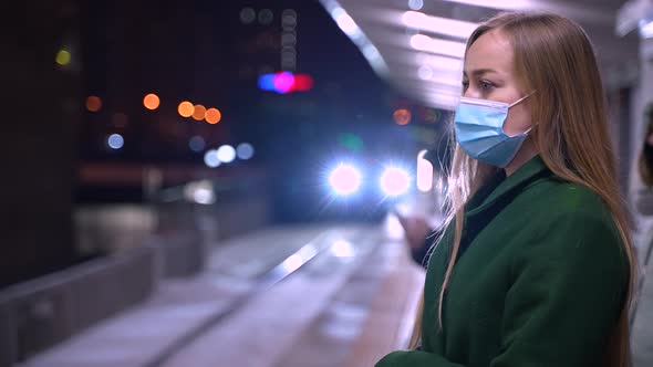 Masked Woman Waiting for Metro Train on Platform alt