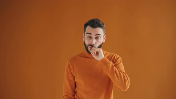 Portrait of Bearded Guy Sneezing Then Wiping Nose and Smiling Looking at Camera alt