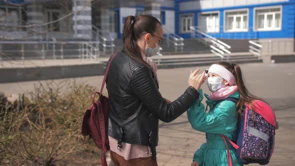 Mom Adjusts the Helmet of His Daughter and Sends Her to School