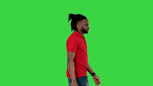 Young African American Man Walks and Takes a Look at His Watch on a Green Screen Chroma Key