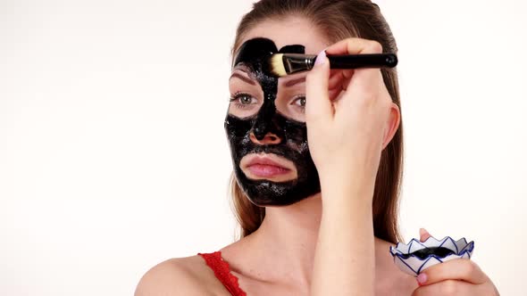 Girl Applying Black Carbo Mask to Face