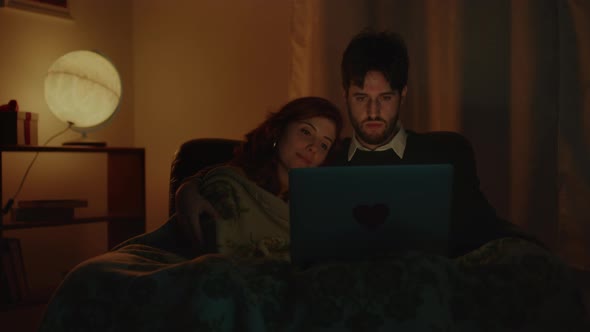 Couple watches movies on the sofa alt