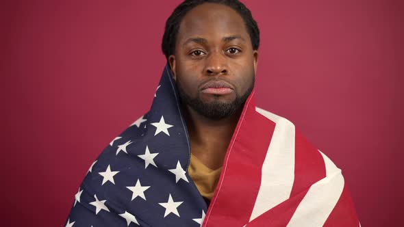 Confident African American Man Standing Covered with United States Flag alt