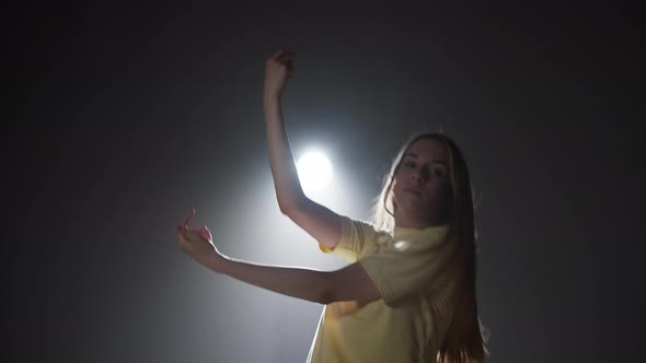 Professional Choreographer Woman Dancing Contemporary on Dark Background with White Light in Studio alt