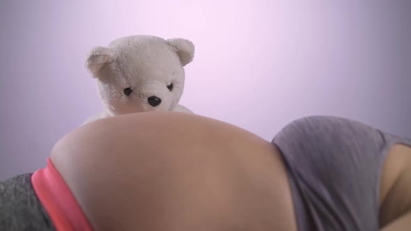 Woman expecting a baby with a cute bear at her belly.