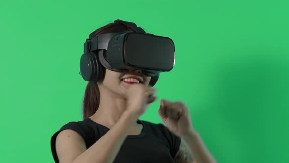 VR game playing. Asian teenager woman playing virtual reality game by VR headset. green screen