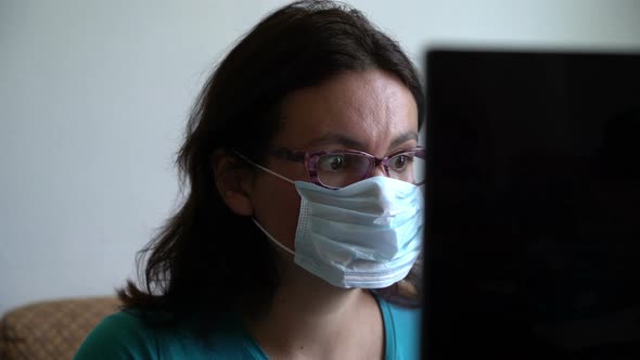 Woman in Mask and Glasses, Reading New About Pandemia of Virus on Laptop, Looking Scared Shocked and