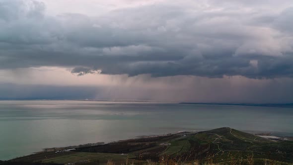 Heavy rainstorm moving over Utah Lake with thick dark clouds alt