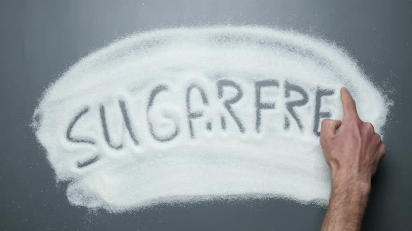 Sugarfree word written on sugar surface. Stop diabetes. Prevent obesity and cardiovascular diseases. alt