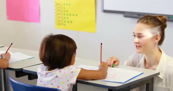 Teacher helping kids with their homework in classroom alt