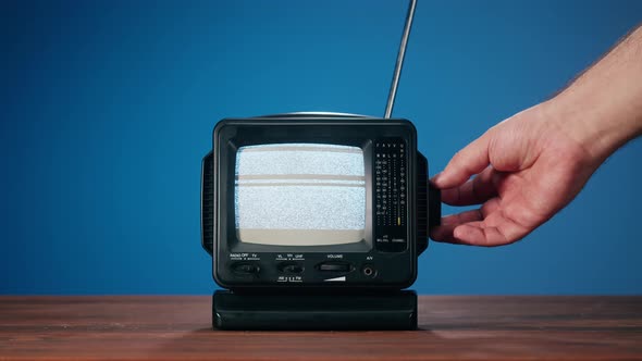 Small Old Television with Grey Interference Screen on Blue Background alt