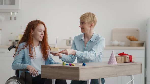 Little Girl in Wheelchair Blowing Candle on Birthday Cake and Making Wish for Recovery Celebrating alt
