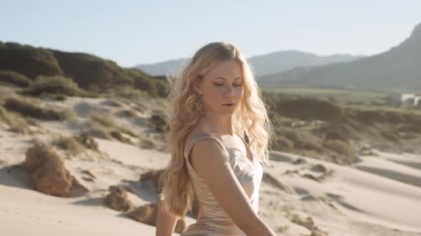 Beautiful Woman In Gold Dress Dancing On Beach alt