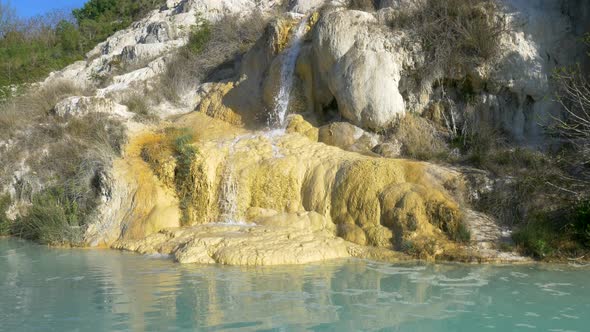 Geothermal pool and hot spring in Tuscany, Italy. Bagno Vignoni natural thermal waterfall in the mor alt