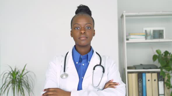 Young Adult Smiling Black Female Doctor Looking at Camera Standing Arms Crossed alt