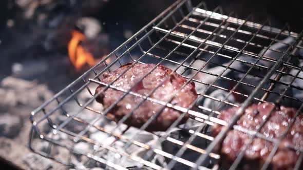 Beef Burgers Cutlets are Roasting on the Charcoal Barbecue Grill alt