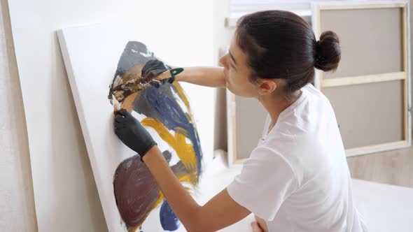 Elegant Artist Sits in Yoga Pose on Wooden Floor and Draws alt