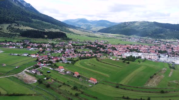 High and Wide Overhead Shot of Small Romanian Town a Village Close to Mountains