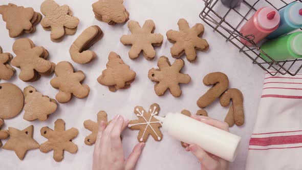 Decorating gingerbread cookies with royal icing for Christmas. alt