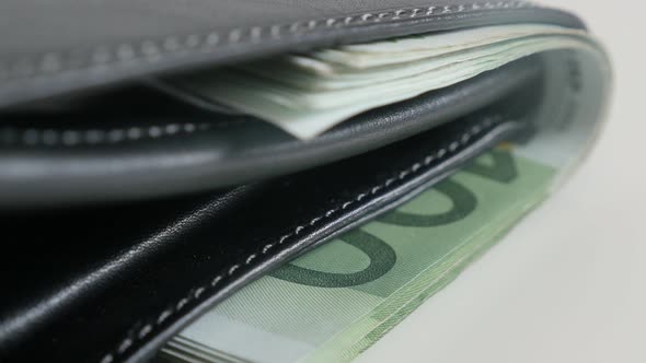 Tiling over paper money   in black leather wallet  3840X2160 UltraHD footage - Euro banknotes in bi- alt