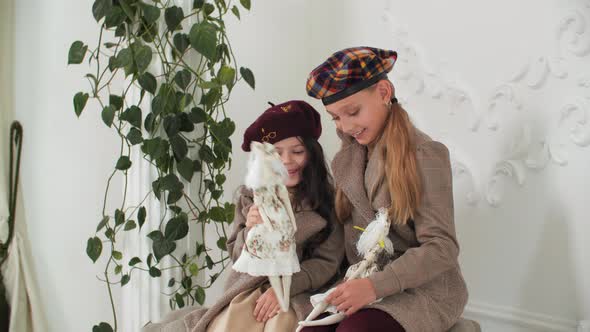 Adorable Stylish Girls in Coats and Berets Posing with Elegant Vintage Dolls alt