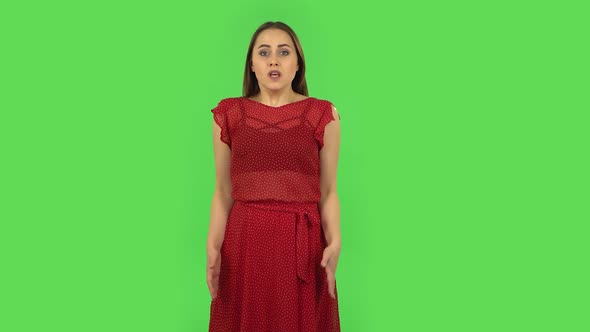 Tender Girl in Red Dress Is Upset, Waving Her Hands in Indignation, Shrugging. Green Screen alt