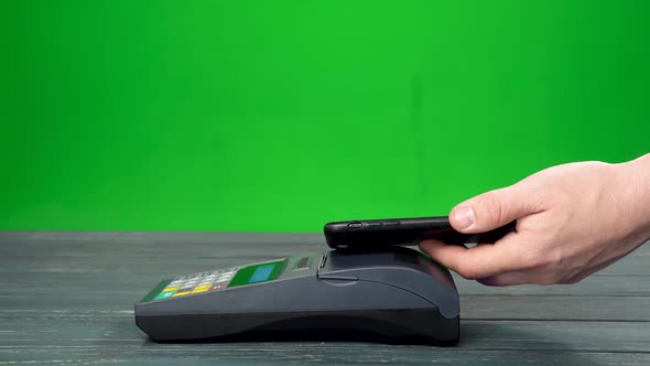 Close Up of Man Pays Something in a Paper Bag with Nfc System and a Smartphone Device Wirelessly alt