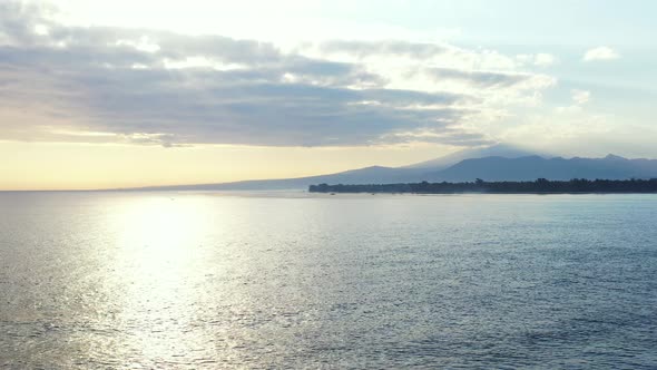 Tropical flying island view of a paradise sunny white sand beach and blue sea background in 4K alt