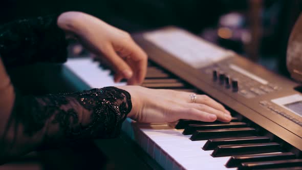 A woman plays a synthesizer. Musician's hands. A girl plays an electric piano. Close-up