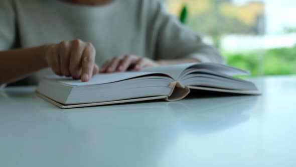 Closeup of a young asian woman reading book