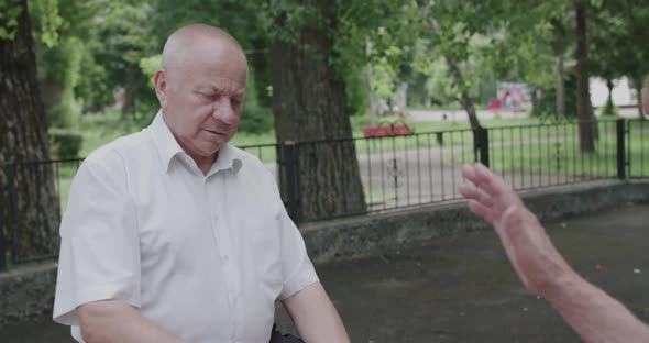 View of Senior Man in the Process of Playing Chess on Street Bench alt