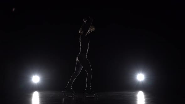 Female Is Dancing in Kangoo Jumps Shoes on Black Background alt