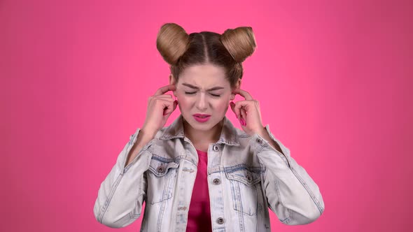 Girl Screams, She Does Not Want To Hear Anything. Pink Background. Slow Motion alt