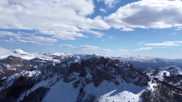 Aerial drone view of difficult access mountain peak for climbers during a winter sunny day alt