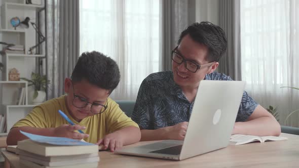 Caring Father Help Son Learn Online From Home. Homeschooling Conducted By Parent alt