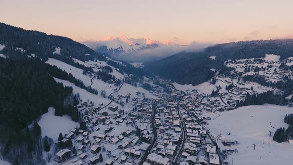 Aerial Of Alps Village In Valley Between Mountains