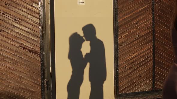 The Wall Reflects the Shadows of Lovers Kissing at Sunset
