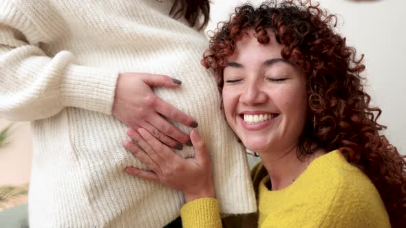 LGBT Lesbian Pregnant Woman Having Tender Moment Listening Belly with Her Wife alt