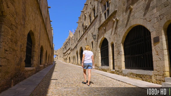 Rear View of Woman Walking Down Empty Street of Knights on the Greek Island of Rhodes alt