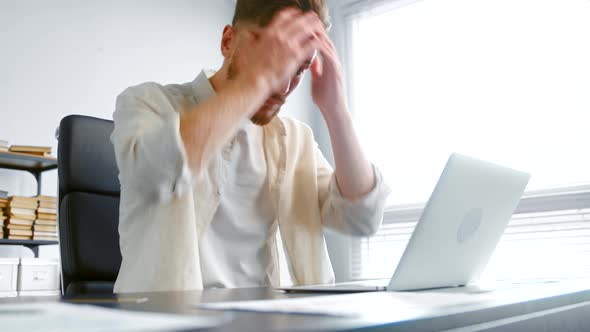 Professional company employee types on laptop alt