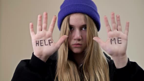 Portrait of a Frustrated Teenage Girl Showing Her Palms with the Inscription HELP ME alt