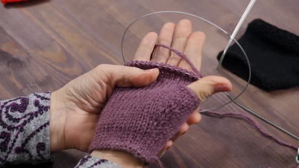 A Woman Knits a Fingerless Glove With Violet Yarn