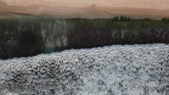 Aerial Top View of Ocean Waves Break on a Beach