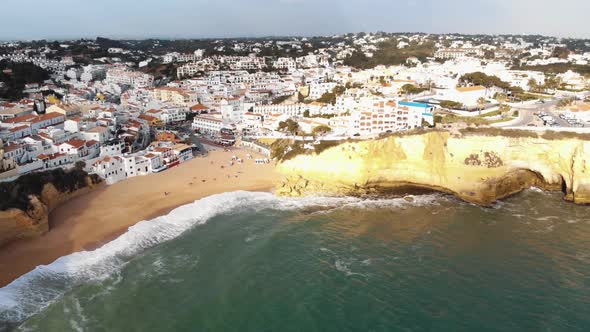 Panoramic view of Carvoeiro Beach and townscape at sunset - Wide Aerial shot alt